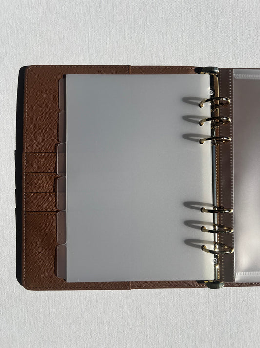 Brown leather-bound notebook with a clear plastic A5 dividers on a white background